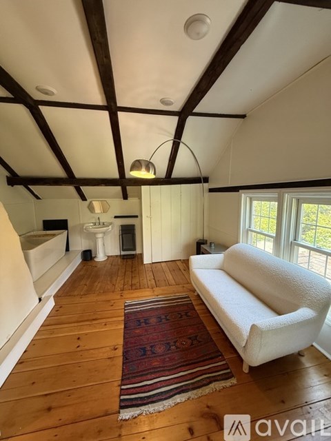 A living room with a white couch and a rug.