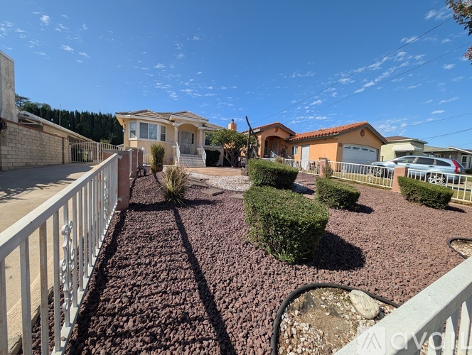 A residential area with houses and a gravel driveway.