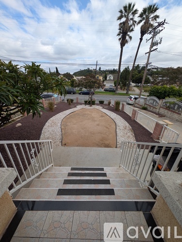 A staircase with a metal railing leads down to a sandy area.