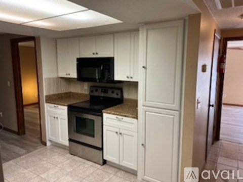 A kitchen with white cabinets and a black stove top oven.
