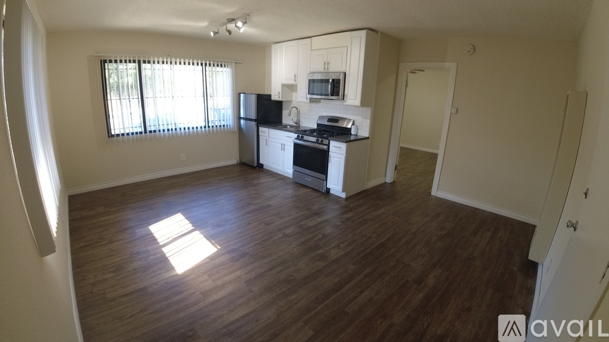 A kitchen with a refrigerator, microwave, and oven is available for rent.