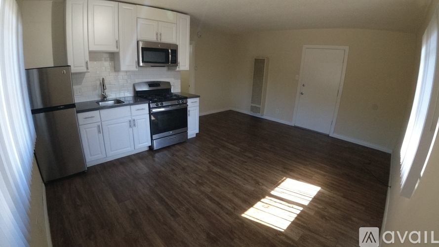 A kitchen with white cabinets and a stainless steel refrigerator.