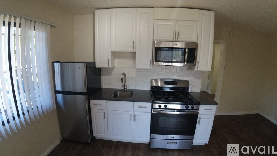 A kitchen with white cabinets and stainless steel appliances.