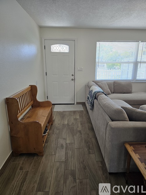A living room with a grey couch and a wooden bench.