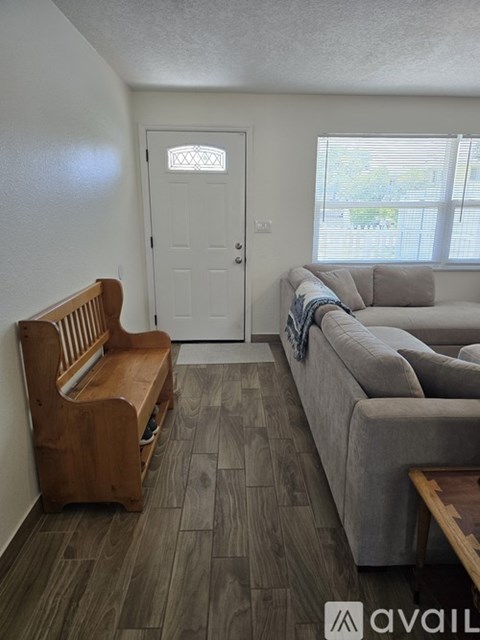 A living room with a grey couch and a wooden bench.