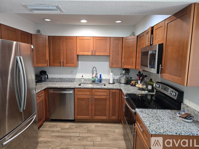A kitchen with wooden cabinets and granite countertops.