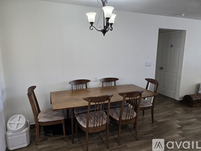 A dining room with a wooden table and chairs.