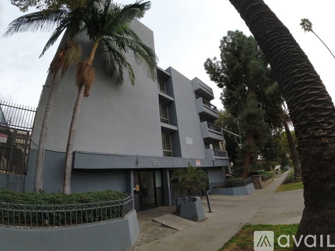 A building with a balcony and a tree in front of it.