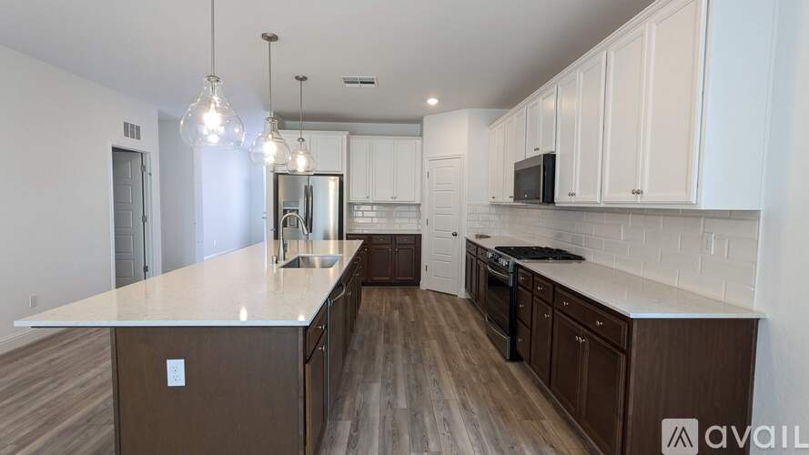 A kitchen with white cabinets and a brown island.