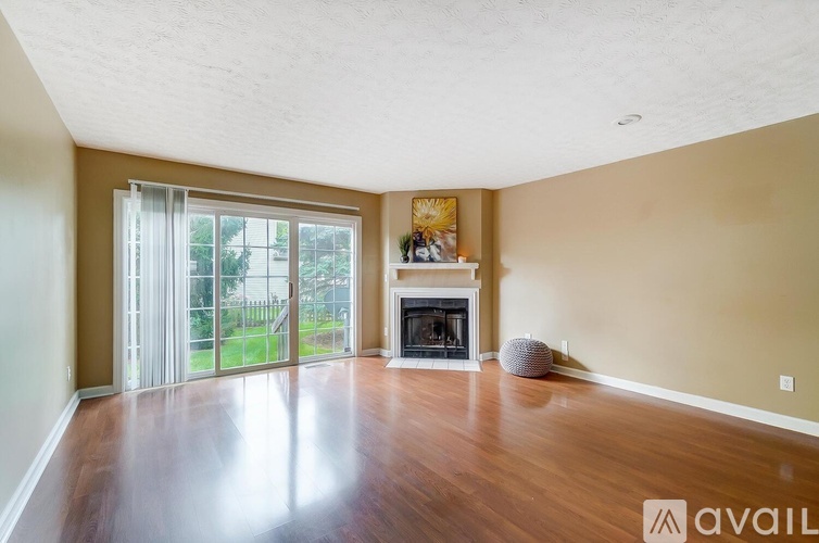 A spacious room with a fireplace and sliding glass doors.