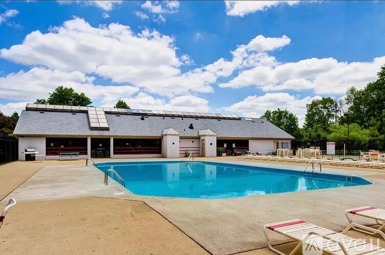 A large swimming pool in front of a house with a garage.