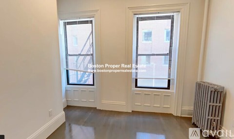 A room with a window and a radiator on the floor.