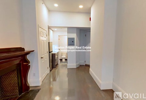 A hallway with a wood staircase and a landing with a door.