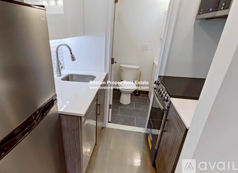 A modern kitchen with a stainless steel refrigerator and a white countertop.