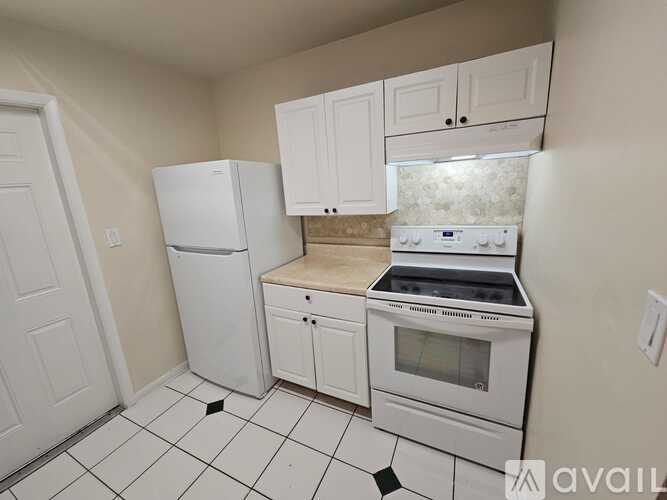 A kitchen with white appliances and cabinets.