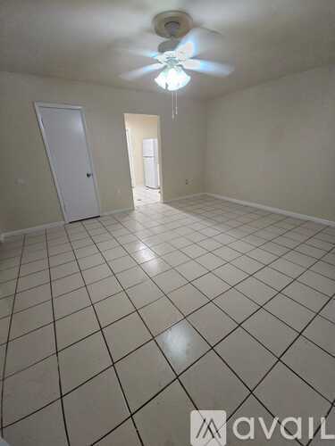 A room with a ceiling fan and tile flooring.
