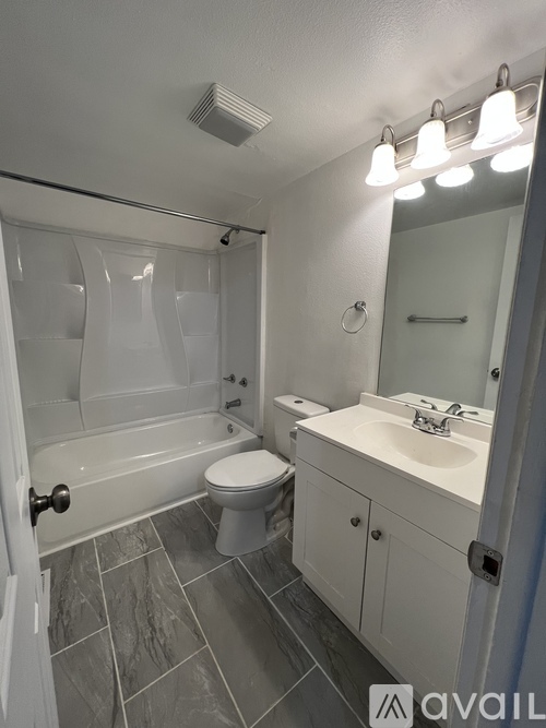 A bathroom with a toilet, sink, and shower.