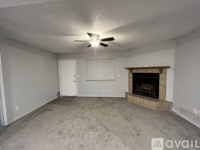 A room with a fireplace and a ceiling fan.
