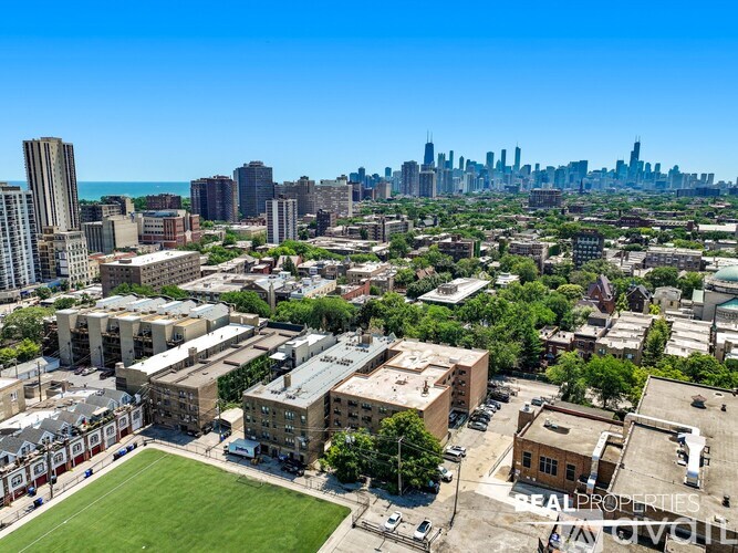 A cityscape with a mix of residential and commercial buildings, with a clear blue sky above.