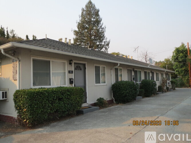 A row of houses with a tree in front of the first house.