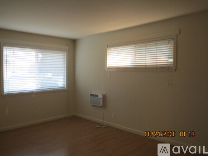 A room with a window and a wall-mounted air conditioner unit.