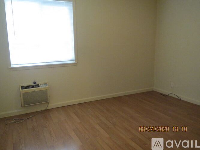 A room with a window and a wall-mounted air conditioner.