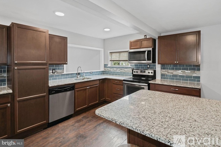 A kitchen with brown cabinets and a granite countertop.