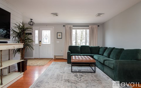 A living room with a green couch and a wooden coffee table.