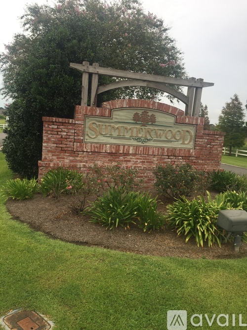 A sign that says Summerwood in front of a grassy area.