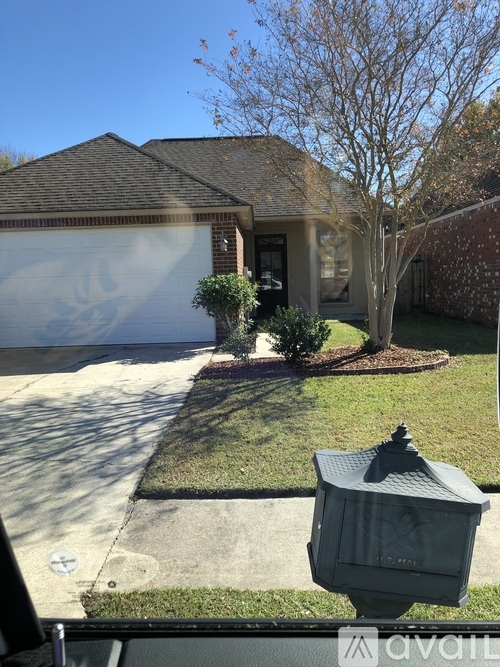 A house with a driveway and a mailbox in front.