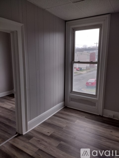 A room with a window and wooden floors.