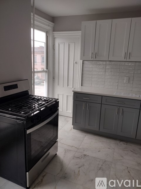 A kitchen with a black oven and white cabinets.