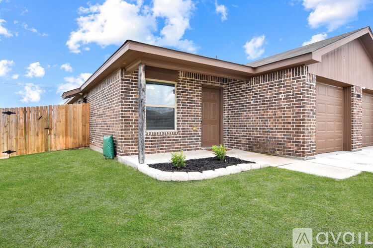 A house with a brown brick exterior and a brown door is for sale.