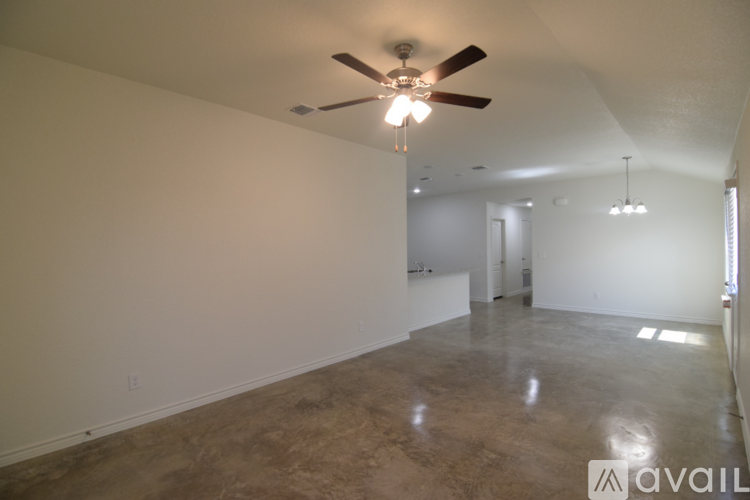 A spacious room with a ceiling fan and a light fixture.