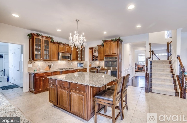 A kitchen with wooden cabinets and a marble countertop.