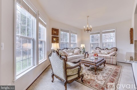 A living room with a sofa set and a chandelier.