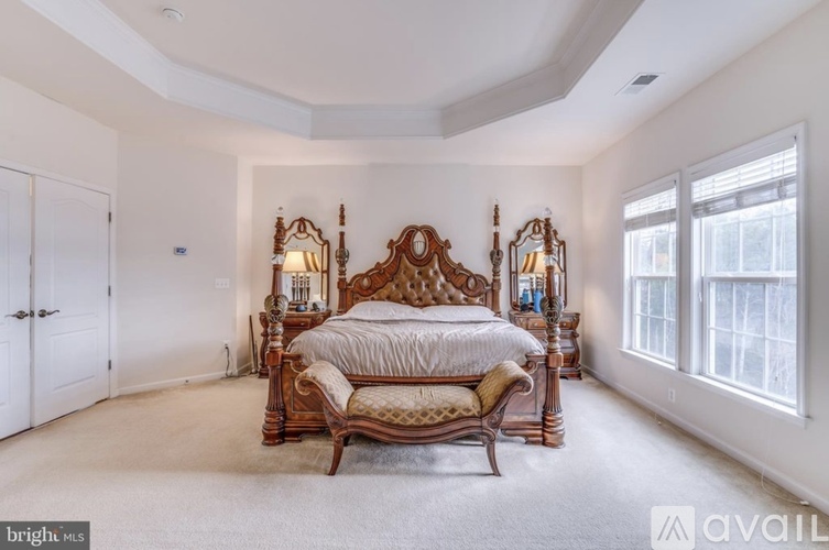 A bedroom with a large bed and a mirror on the wall.