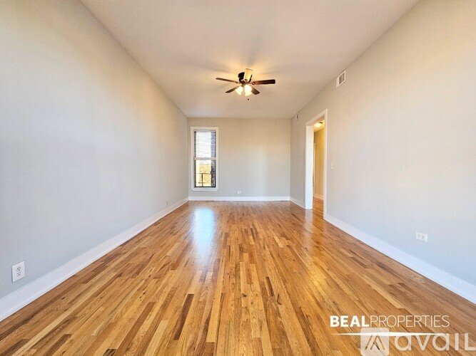 A room with wooden flooring and a ceiling fan.
