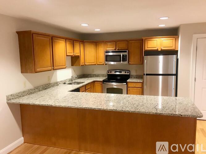 A kitchen with wooden cabinets and granite countertops.