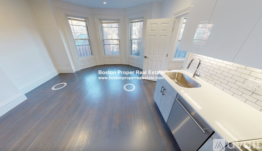 A kitchen with wooden floors and white walls.