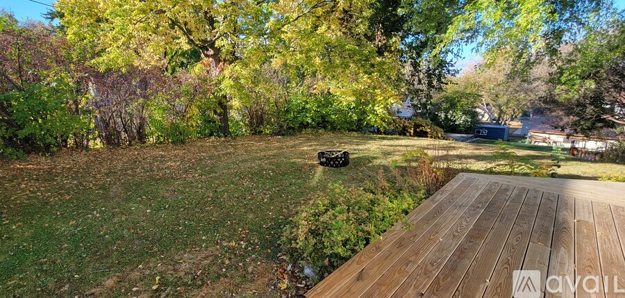 A backyard with a wooden deck and a grassy area.
