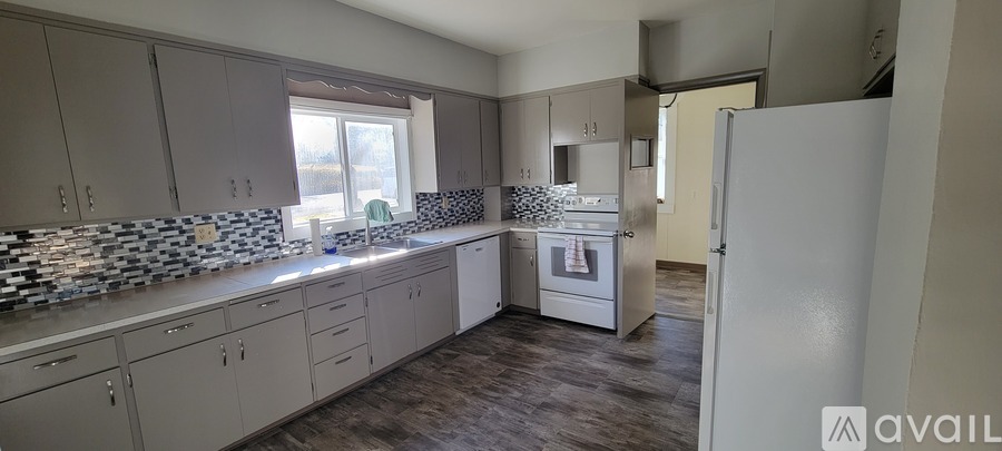 A kitchen with a white refrigerator and a window.