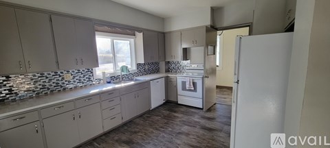 A kitchen with a white refrigerator and a window.
