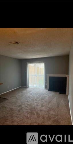 A living room with a flat screen TV and a sliding glass door.