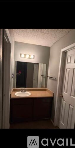 A bathroom with a sink and mirror.