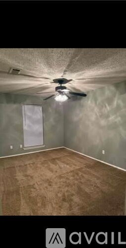 A room with a ceiling fan and a door.