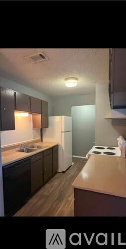 A kitchen with a stove top oven and a sink.