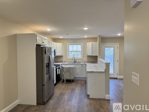 A kitchen with a refrigerator, cabinets, and a countertop is available for rent.