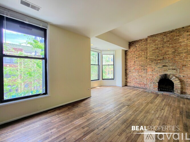 A room with a brick wall and wooden flooring is available for rent.
