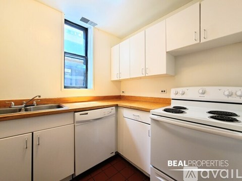A kitchen with white appliances and cabinets is available for rent.